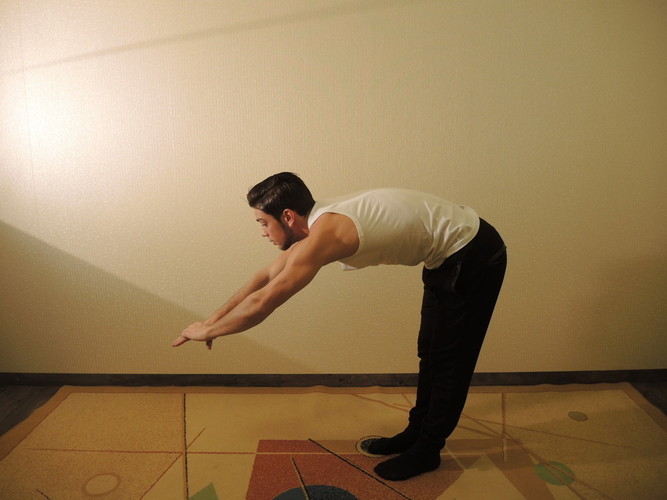 Pirmas pratimas. Iškvėpdami lenkitės žemyn, žvilgsnį išlaikydami prieš