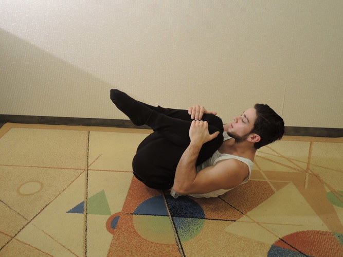 Nugaros mankštos devintas pratimas kelių pritraukimas prie smakro